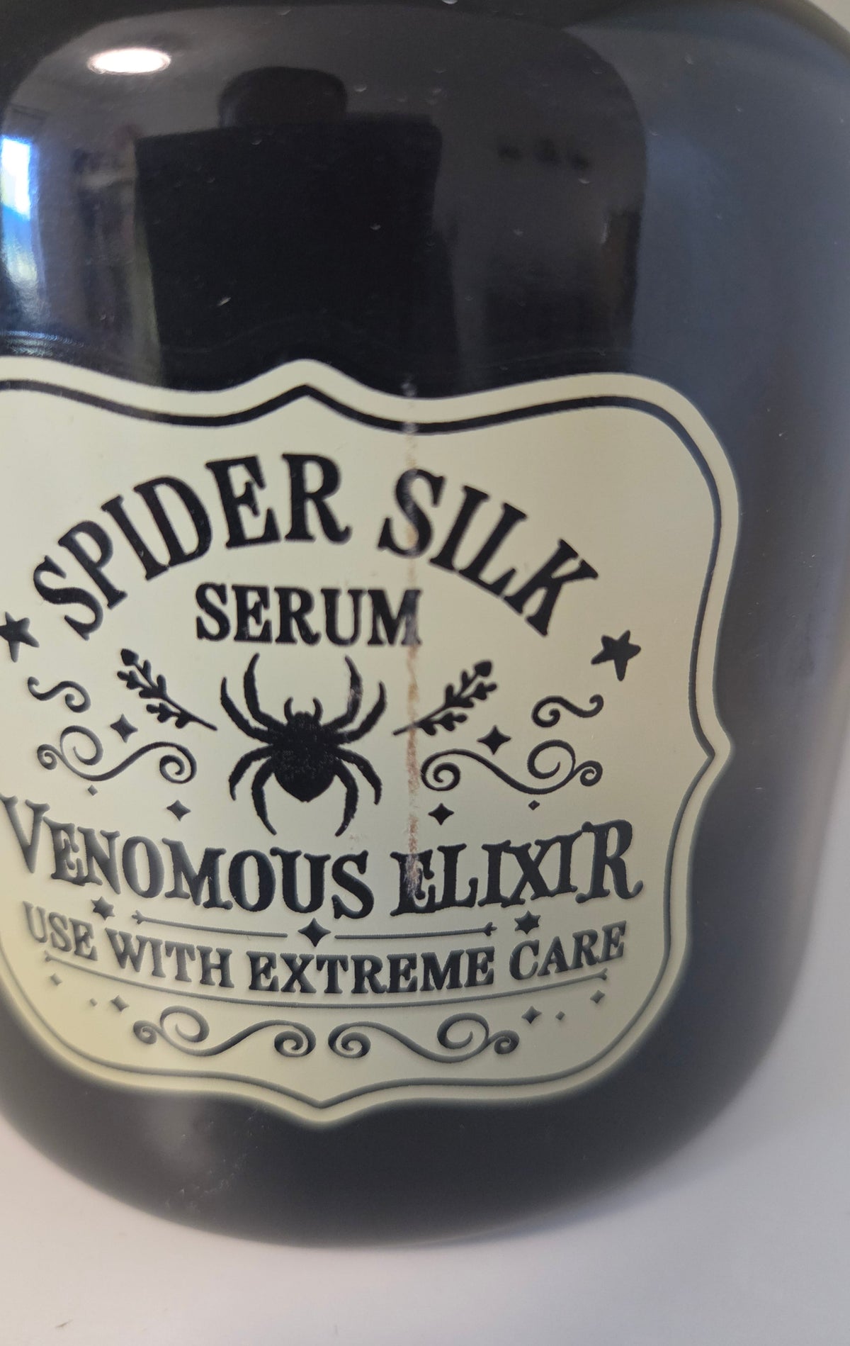Quemador Bote de Veneno Spider Silk Outlet - detalle línea pegamento etiqueta