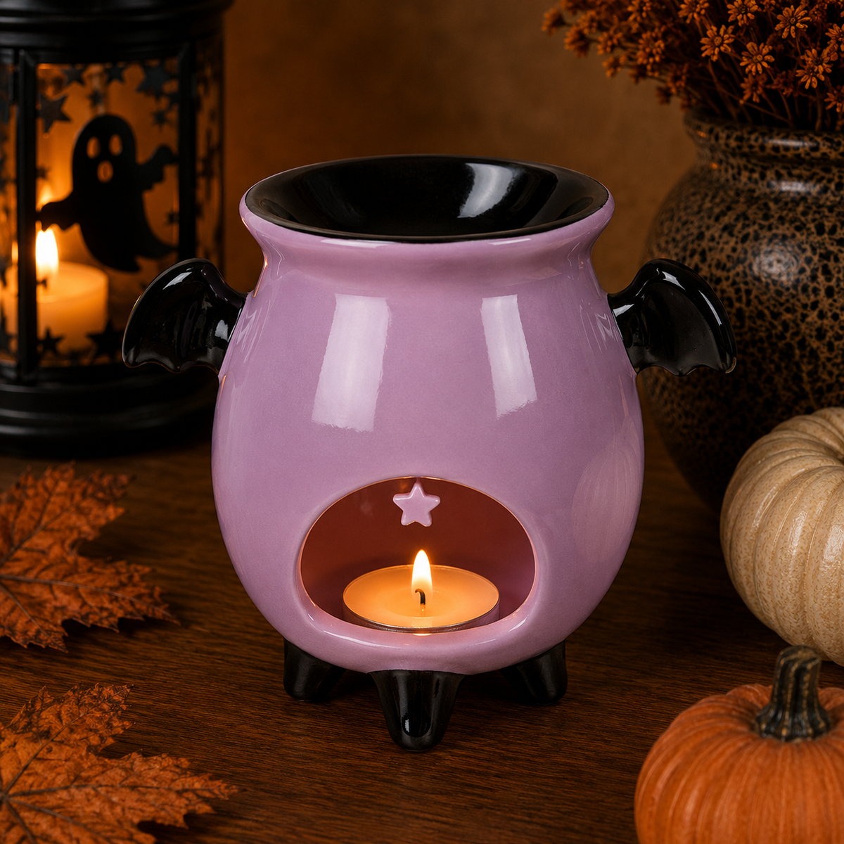Quemador Candy Cauldron lila Halloween vista lateral con vela de té encendida